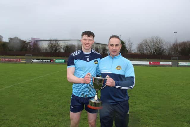 Lumen Christi coach Michael McCullagh pictured with team captain Eoin Canavan and the Ward Cup after the school's victory in O'Donnell Park, Letterkenny on Friday.