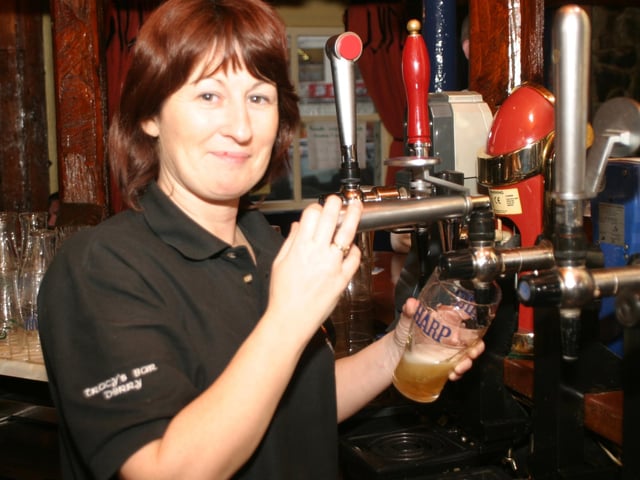 Fionnoula pulls a pint for a regular at Tracy's Bar. :.
