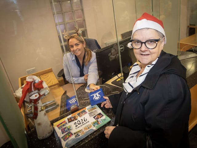 A customer picking up one of the 2026 Derry Credit Union calendars on Saturday. : .
