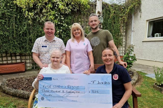 Kay McGlinchey handing over a cheque for £235 to Christina McKeegan from Foyle Search and Rescue. Also pictured is staff at Ardlough Care Home, where Kay resides.