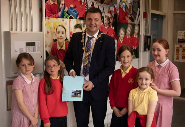 The Mayor, Ruairi McHugh is presented with a special card made by Mr. McLaughlin's pupils during his visit to Steelstown Primary School last week to take part in their 'A Day of Welcome' event.