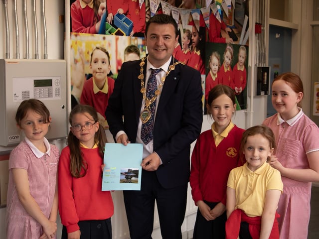 The Mayor, Ruairi McHugh is presented with a special card made by Mr. McLaughlin's pupils during his visit to Steelstown Primary School last week to take part in their 'A Day of Welcome' event.