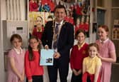 The Mayor, Ruairi McHugh is presented with a special card made by Mr. McLaughlin's pupils during his visit to Steelstown Primary School last week to take part in their 'A Day of Welcome' event.