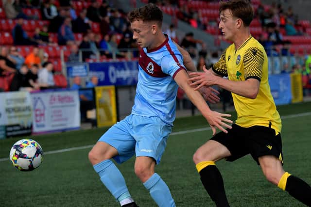 Institute’s Tiarnan McKinney gets the ball ahead of Knockbreda’s Smith.  Photograph: George Sweeney.