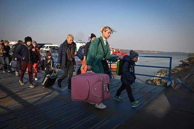 Refugees from Ukraine walk on the jetty after arriving by ferry at the Romanian-Ukrainian border point Isaccea-Orlivka on March 24, 2022. (Photo by Daniel MIHAILESCU / AFP) (Photo by DANIEL MIHAILESCU/AFP via Getty Images)