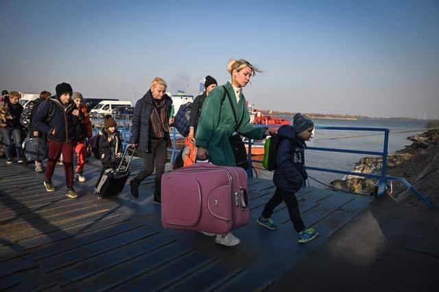 Refugees from Ukraine walk on the jetty after arriving by ferry at the Romanian-Ukrainian border point Isaccea-Orlivka on March 24, 2022. (Photo by Daniel MIHAILESCU / AFP) (Photo by DANIEL MIHAILESCU/AFP via Getty Images)