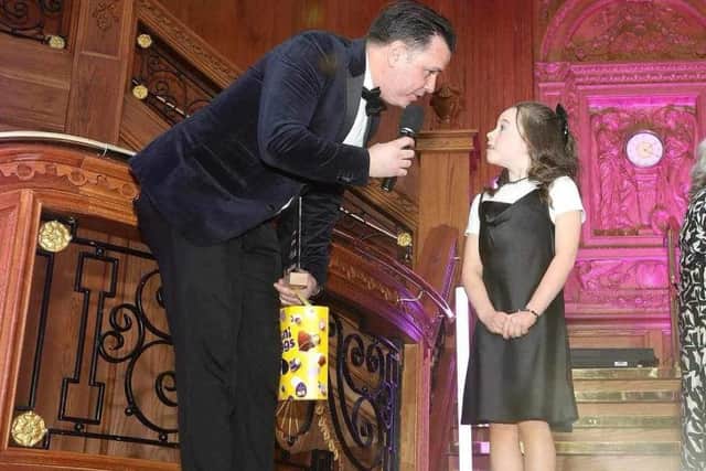 Seven year old Yazmin Doherty collects her award from host Pete Snodden at the glittering Families First award recently.