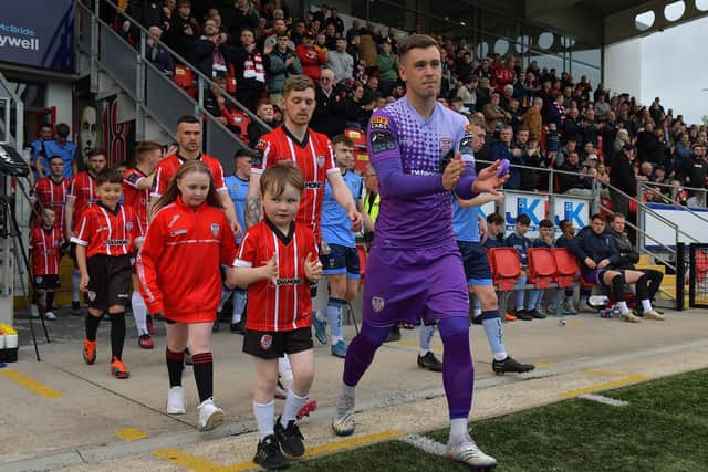 Derry City goalkeeper Brian Maher leads out the teams with mascots on Friday evening last. Photo: George Sweeney. DER2320GS – 136