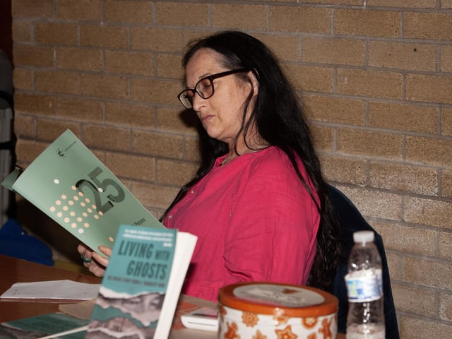 Little Acorns Bookstore owner jenni Doherty reading through Brian Rowan's '25 Pieces' before the start of Thursday's Feile 23 event at Pilot's Row Centre, Derry.