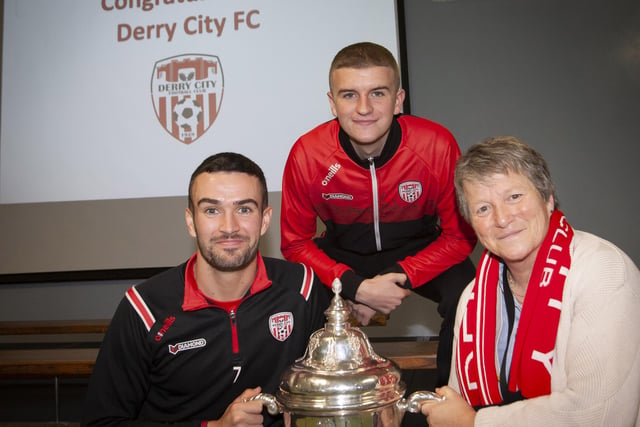 Derry players Michael Duffy and Caoimhin Porter and the FAI Cup pictured with Ms. Linda Heaney.