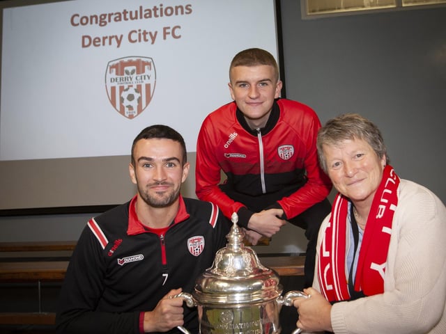 Derry players Michael Duffy and Caoimhin Porter and the FAI Cup pictured with Ms. Linda Heaney.