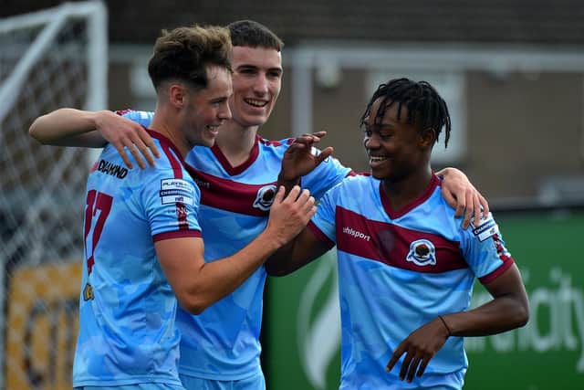Institute’s Mark Mbuli celebrates his first half goal against Newington, at the Brandywell on Saturday afternoon, with Michael Harris and Kirk McLaughlin.  Photograph: George Sweeney. DER2333GS – 94 