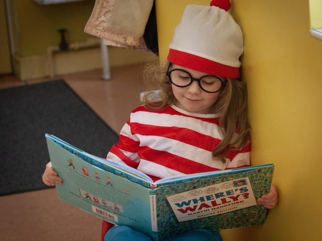 A Primary 1 pupil relaxes with some good reading material during World Book Day at Hollybush PS.