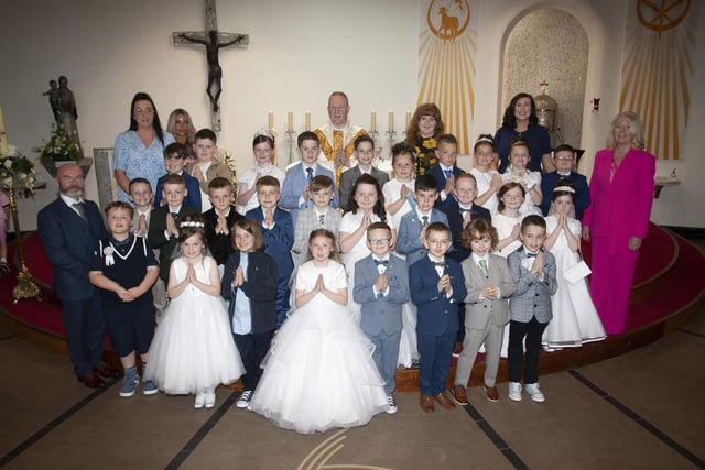 Pupils from Mrs. Aileen Mullan’s class at St. Brigid’s Primary School, Carnhill who received the Sacrament of First Holy Communion at St. Brigid’s Church on Wednesday last. At front left is Mr. Mark Doherty, and at back from left, Ms. Ashleigh McGowan, Ms. Eimear McChrystal, Fr Sean O’Donnell, Ms. Molly Meehan, Mrs. Aileen Mullan, class teacher and Ms. Mary McCallion, Principal. (Photos: Jim McCafferty Photography) 