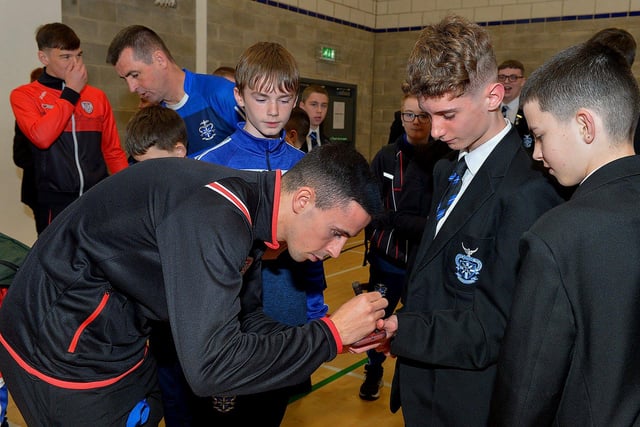 Derry Citys Jordon McEneff signs autographs for pupils  during a visit to the school, with the FAI Cup, on Monday . Photo: George Sweeney. DER2247GS  26