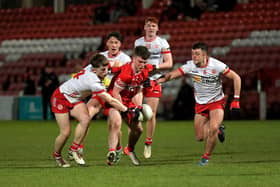 Tyrone players converge on Derry’s Johnny McGuickin. Photo: George Sweeney