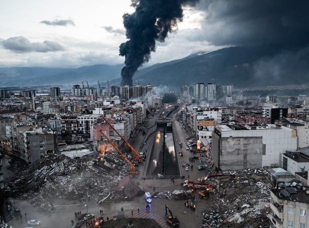 HATAY, TURKEY - FEBRUARY 07: Smoke billows from the Iskenderun Port as rescue workers work at the scene of a collapsed building on February 07, 2023 in Iskenderun, Turkey. A 7.8-magnitude earthquake hit near Gaziantep, Turkey, in the early hours of Monday, followed by another 7.5-magnitude tremor just after midday. The quakes caused widespread destruction in southern Turkey and northern Syria and were felt in nearby countries.  (Photo by Burak Kara/Getty Images)