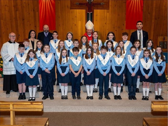 Pictured are pupils from Hollybush Primary School, who made their Confirmations recently. The pupils are pictured with staff and local clergy who officiated at the ceremony.