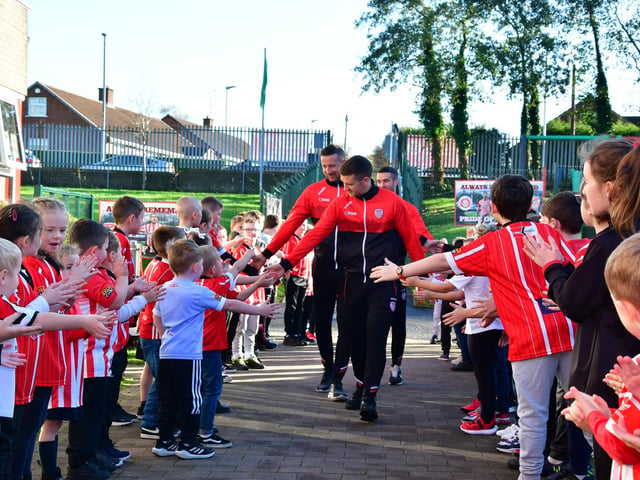 ROUSING RECEPTION. . . . .Derry City players receive special guard of honour reception as they arrive at Steelstown P.S.  on Tuesday morning.