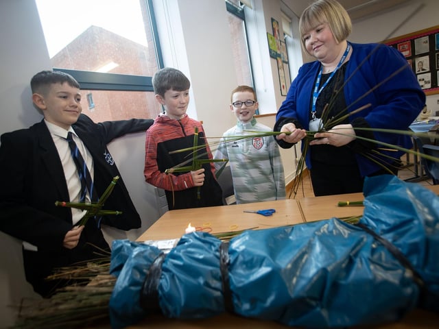 The RE Department's Miss Doherty showing how to make St. Brigid's Crosses to Oisin and Cohen, St. Patrick's PS, Pennyburn. On left is St Columb's student Shane. : .