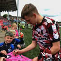 Derry City’s Ciaron Harkin signs a shirt for a young before the game against St Pats on Sunday evening. Photograph: George Sweeney