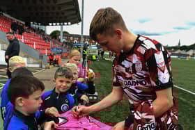 Derry City’s Ciaron Harkin signs a shirt for a young before the game against St Pats on Sunday evening. Photograph: George Sweeney