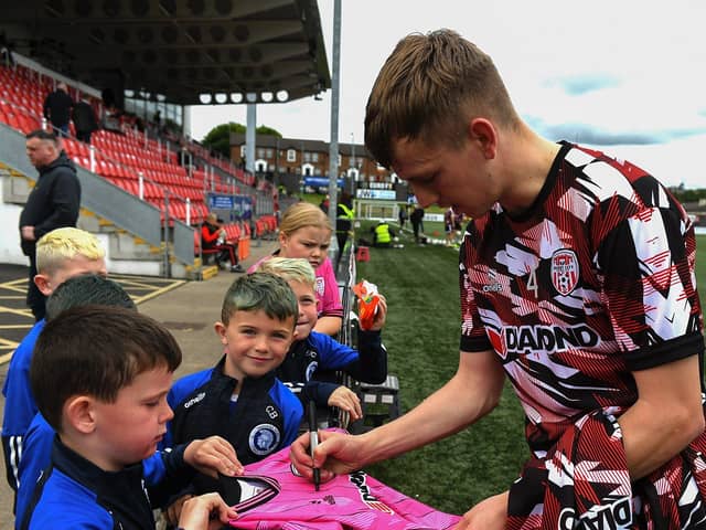 Derry City’s Ciaron Harkin signs a shirt for a young before the game against St Pats on Sunday evening. Photograph: George Sweeney