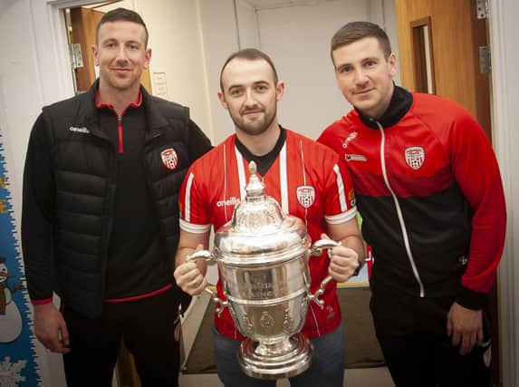 Derry City fan and P7 teacher Mr. Rory O’Donnell pictured with the FAI Cup and Derry players and former Steelstown PS pupils Shane and Patrick McEleney.