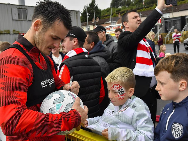 Danny Mullen signs a ball for a fan at the Derry City open training session on Monday morning in Brandywell Stadium. The event was organised at part of the Gasyard Feile. Photo: George Sweeney / Derry Journal
