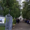 Schoolchildren and others forming a guard of honour ahead of the funeral procession arriving yesterday.