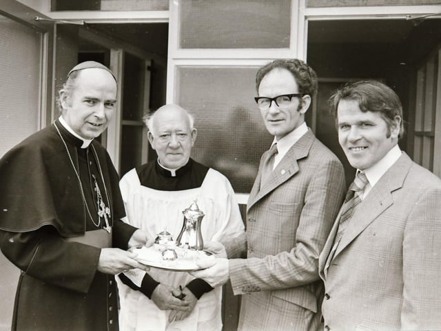 Mr Liam Bryce, District Inspector, Office of Public Works, presenting a silver coffee service on behalf of the teachers and pupils, to Most Reverend Dr Edward Daly, Bishop of Derry, after his Lordship performed the blessing ceremony at the formal opening of the school. Also in the photograph are Rev Daniel McSorley, PP and Mr Daniel Sharkey, school principal.