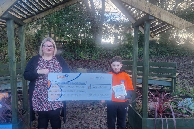 Kian Sweeney presenting a cheque worth £2,485 to SANDS NI