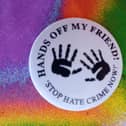 A badge from a previous anti-racism campaign in Derry - Hands Off My Friend.