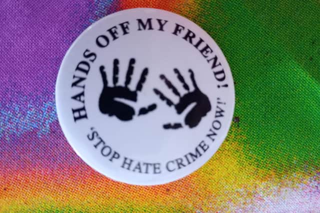 A badge from a previous anti-racism campaign in Derry - Hands Off My Friend.