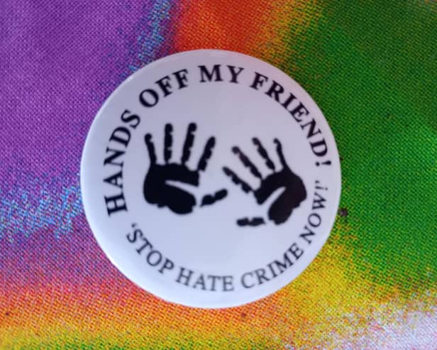 A badge from a previous anti-racism campaign in Derry - Hands Off My Friend.