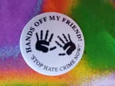 A badge from a previous anti-racism campaign in Derry - Hands Off My Friend.