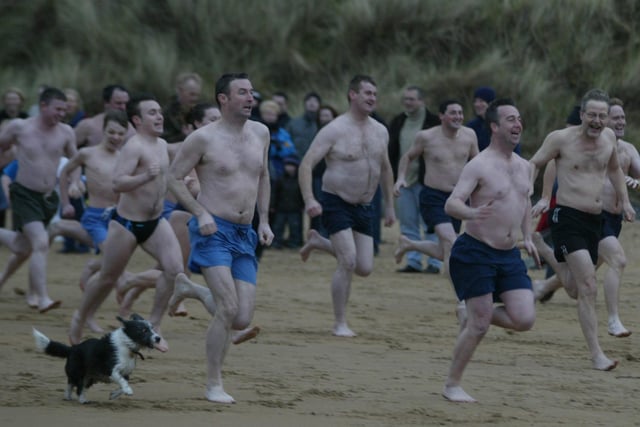 On your Marks! Get Wet, Go!!!  Some of the large attendance at the Culdaff New Years Days swim make a run for the water.  (0301JB01)
