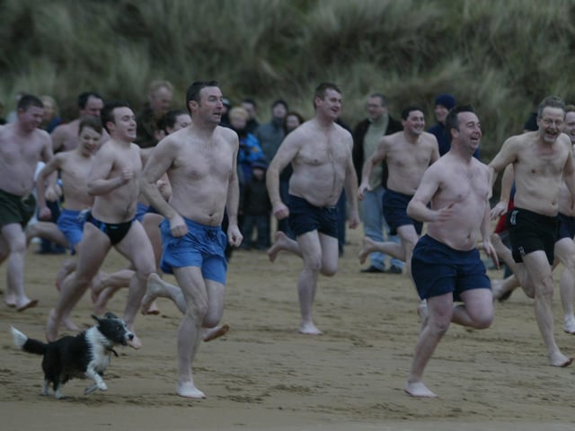 On your Marks! Get Wet, Go!!! Some of the large attendance at the Culdaff New Years Days swim make a run for the water. (0301JB01)