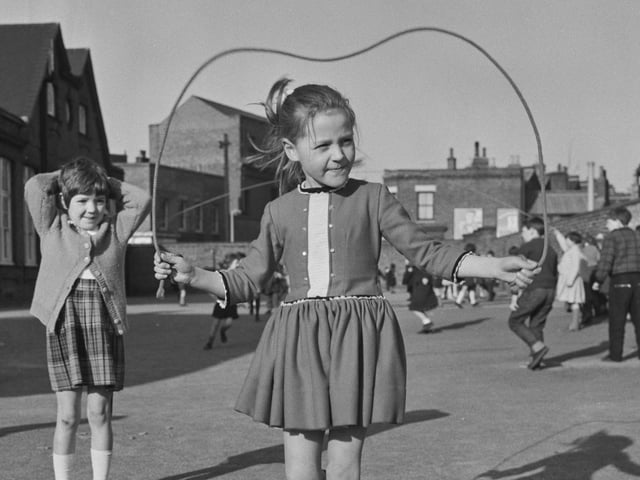 Then as now, skipping ropes were popular as a solo or group activity and had the added bonus of keeping you fit. Pictured are girls skipping in the playground of Christ Church Primary School in Battersea.  (Photo by Evening Standard/Hulton Archive/Getty Images)