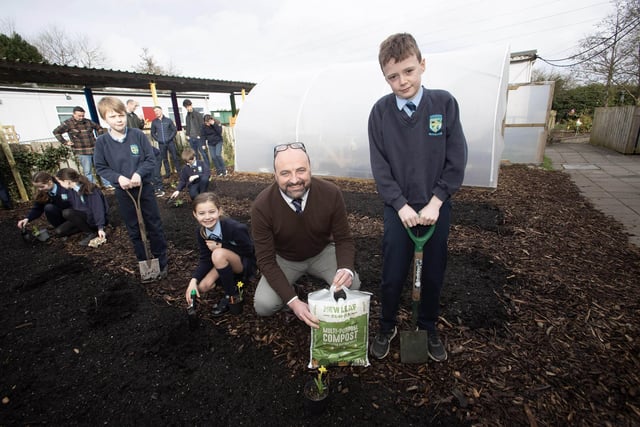 Mr. Feargal Friel, Acting Principal working in the garden area with pupils Luca, Ora and Ollie.