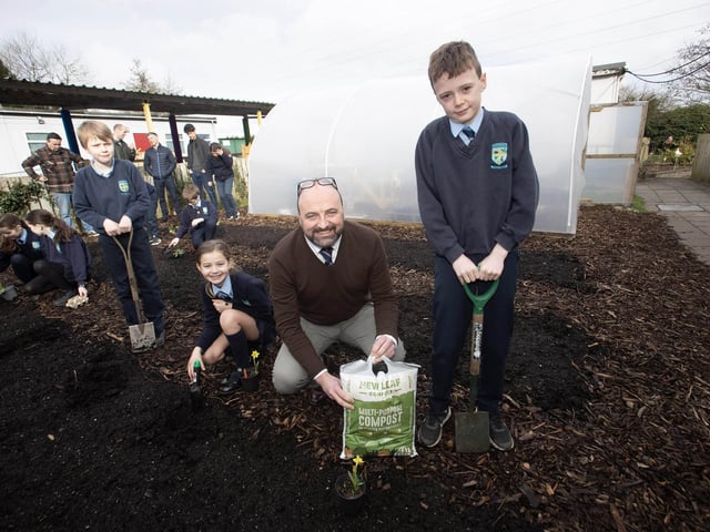 Mr. Feargal Friel, Acting Principal working in the garden area with pupils Luca, Ora and Ollie.