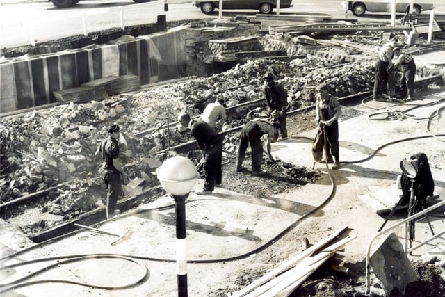 Like skeletons from the past, the old tram lines emerge from the road excavations for the subways at the junction of Angel Street and High Street, Sheffield, in August 1966