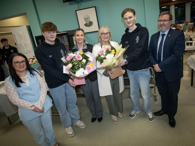 Mrs. King and Mrs. MacDermott receiving bouquets of flowers from Tom Hudson and Aaron O'Doherty, Head Boy at Thursday night's Valedictory celebrations at St. Columb's College. Included are Mrs. Caroline McLaughlin, Principal and Mr. John Johnston, Vice Principal. : .