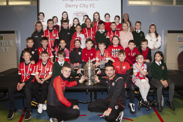 Derry players Caoimhin Porter and Michael Duffy and the FAI Cup pictured with the P6 classes at Greenhaw PS.
