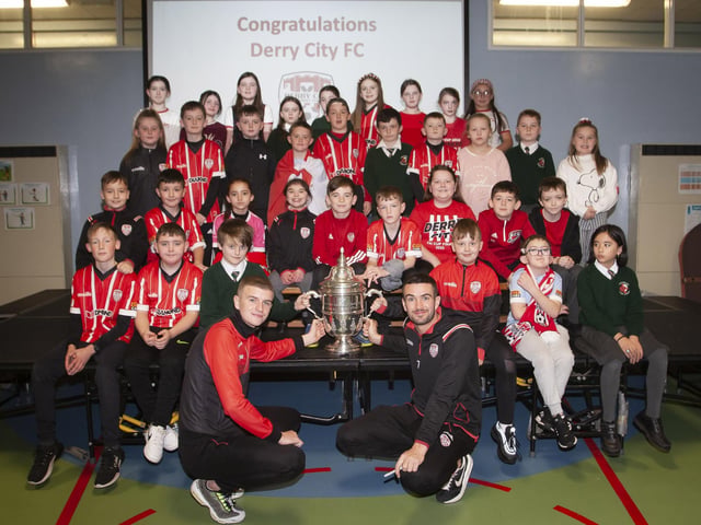 Derry players Caoimhin Porter and Michael Duffy and the FAI Cup pictured with the P6 classes at Greenhaw PS.