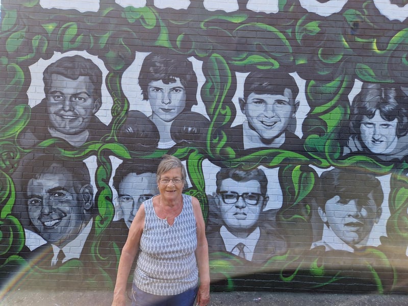 Kay Duddy pictured underneath the portrait of her brother Jackie.