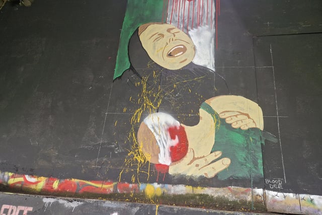 A mural depicting a grieving Palestinian woman holding a dying or sick child was also daubed with paint in the attack.