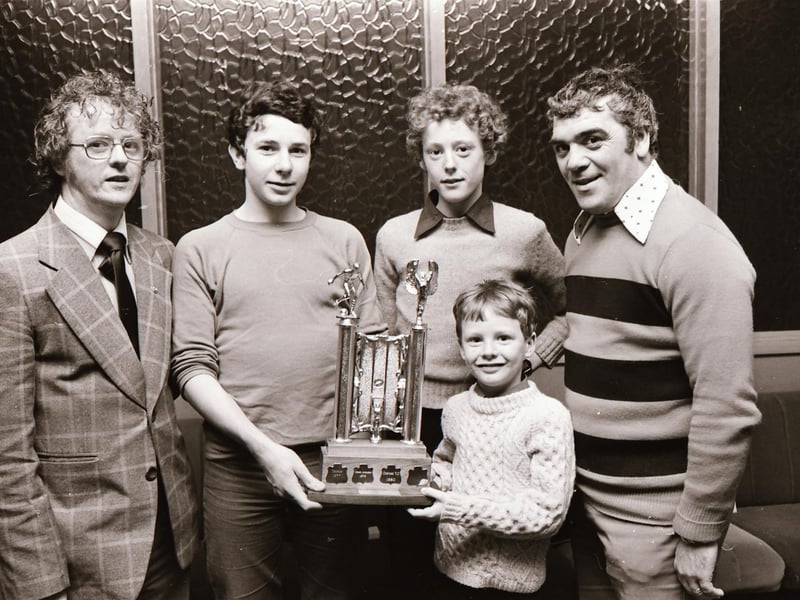 Master Gerry Stewart presenting the Gerry Stewart Memorial Trophy in the under-13 competitions to Martin Taylor, captain of the winners Oxford FC. Also in the group are, from left, Mr. Gerry Stewart, Master Damien Stewart and Mr. Jim Crossan, the D&D Youth FA, vice-chairman.