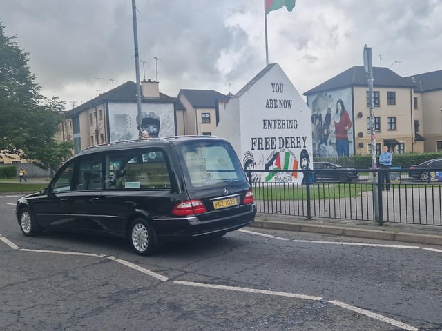 Nell McCafferty's funeral cortege passes Free Derry Corner before making its way up the flyover to the Long Tower