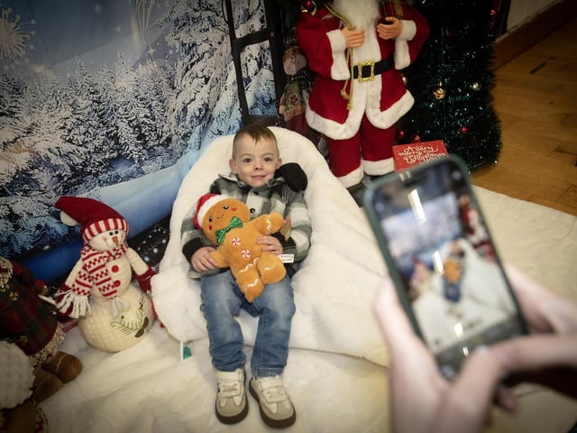 Three years-old Ollie McDonald gets a photo taken at Saturday's 'Christmas Get Together' at Long Tower Youth Club. : .